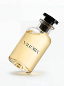 VALLORIA Bliss luxury perfume in a minimalist clear glass bottle with a premium black cap and golden liquid, tilted on a clean white background.